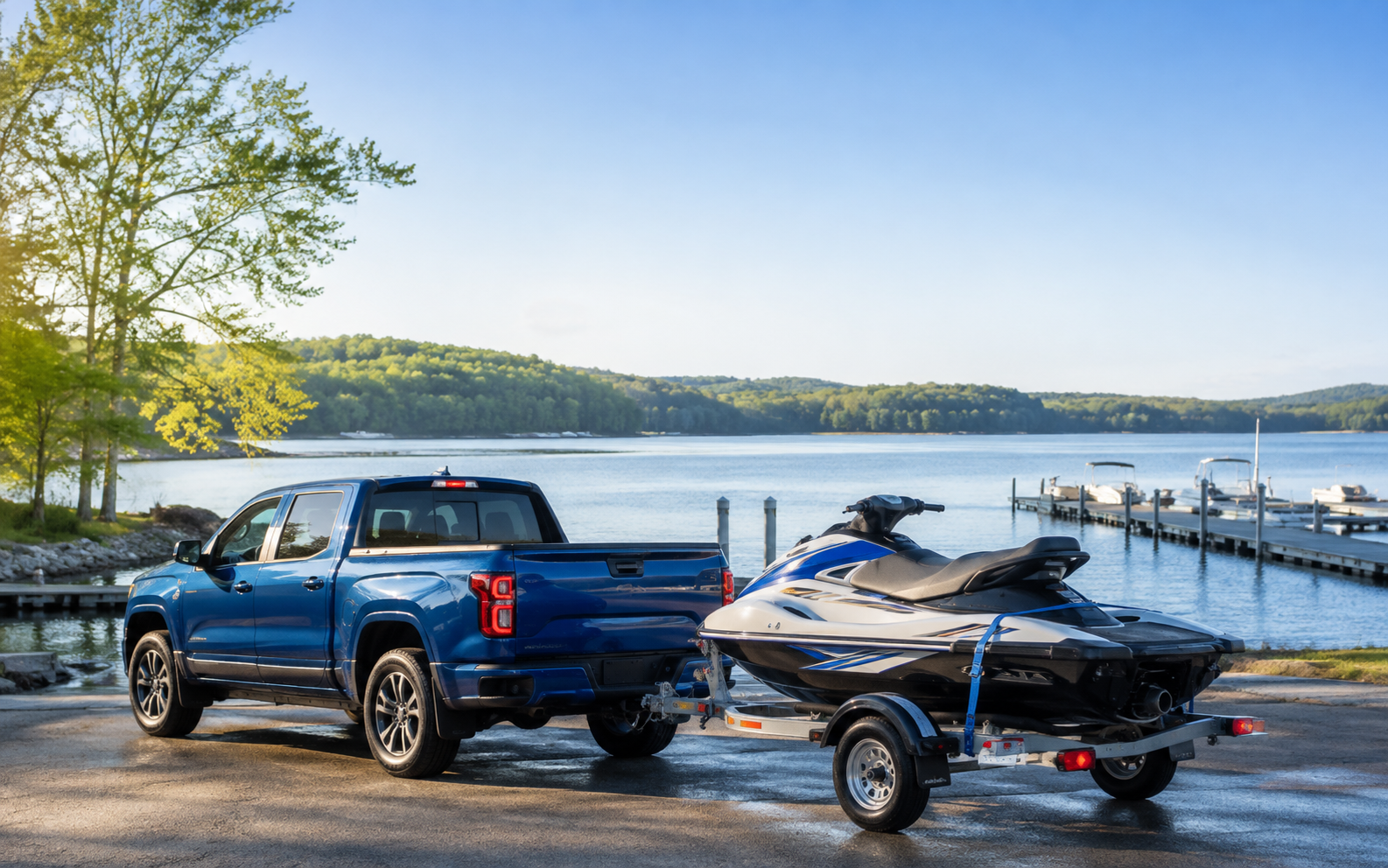 A blue pickup truck towing a personal watercraft toward a dock